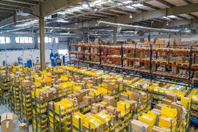 Vista del interior de un almacén lleno de estanterías rebosantes.